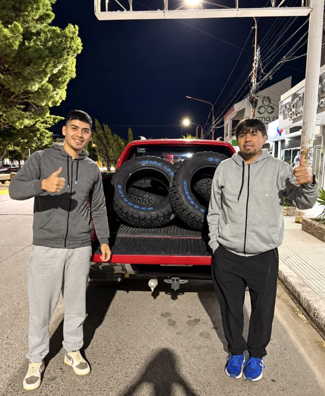 Dos personas junto a cubiertas en una camioneta