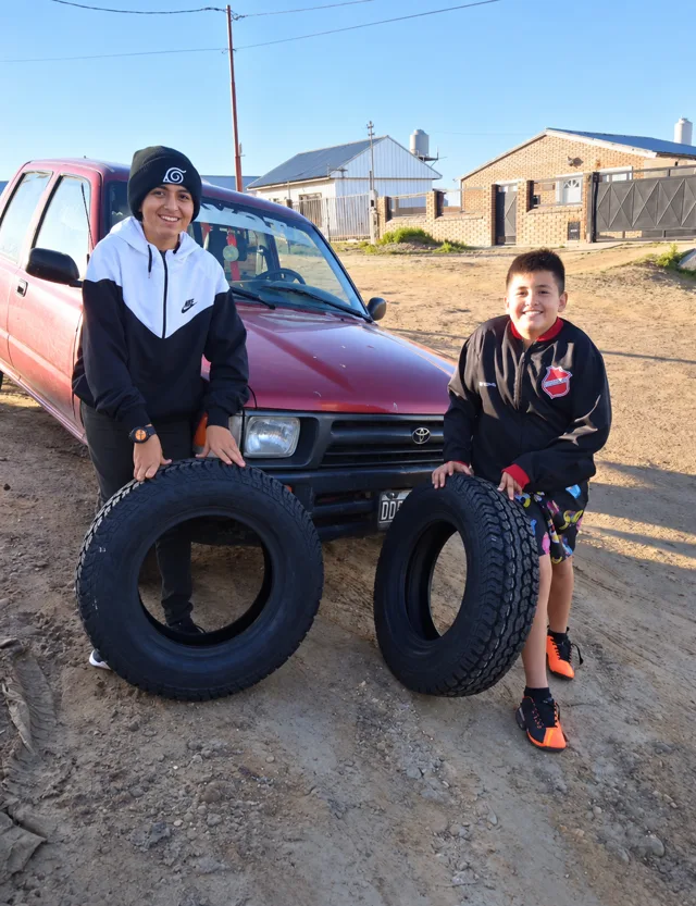 Dos personas con cubiertas junto a una camioneta